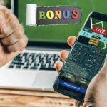 smartphone con un sito di scommesse, sullo sfondo un pc