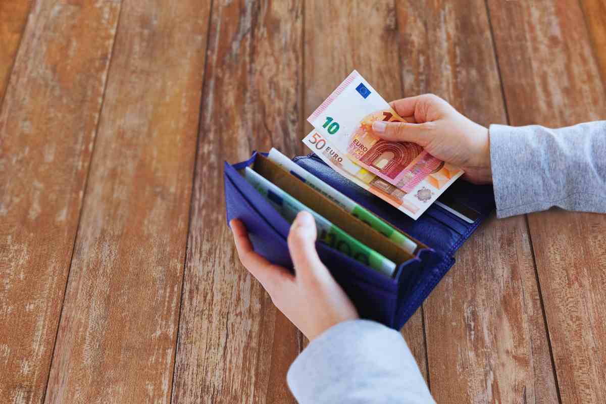 persona mette soldi nel portafogli